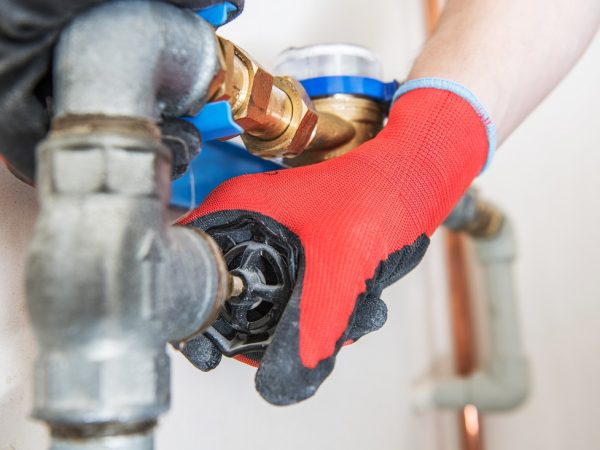 Residential Water Pipeline Valve Closing. Plumbing Industry Concept. Caucasian Plumber Worker.